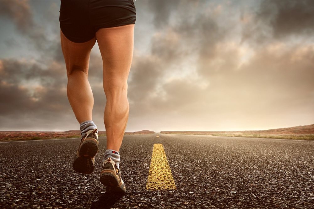 Man running on highway, into the distance.