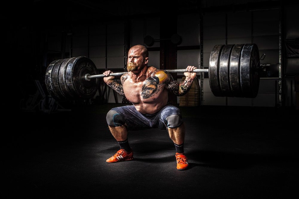 Strong man lifting heavy weights.