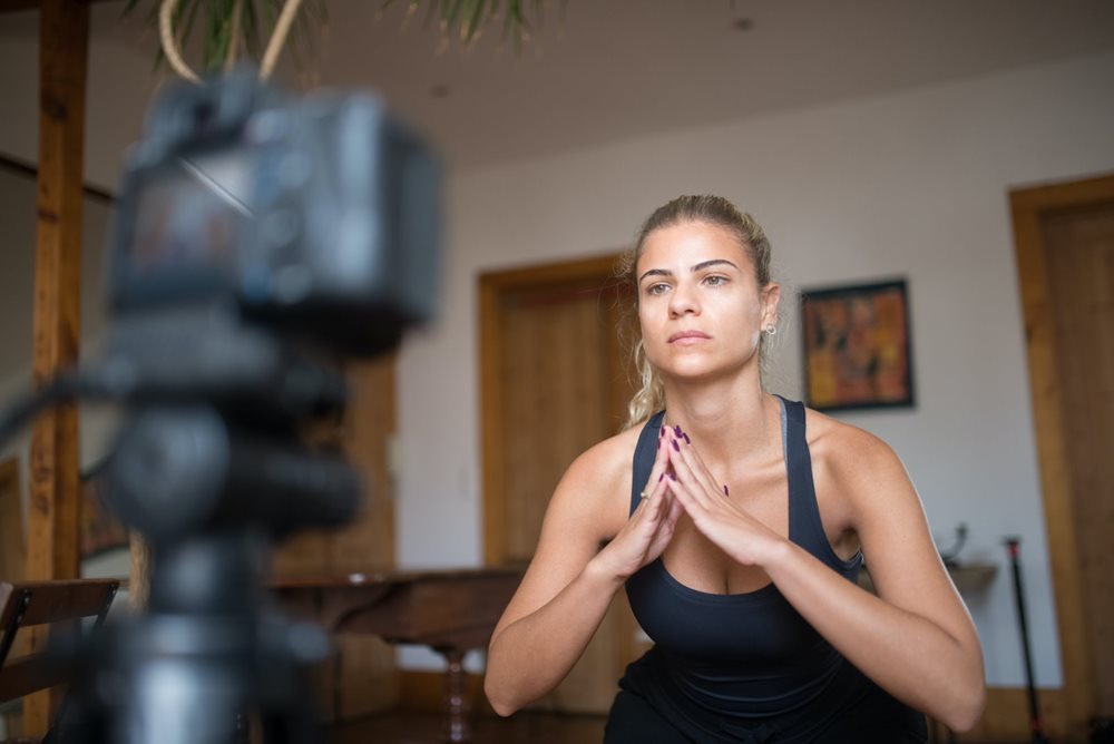 Woman recording fitness content for social media.
