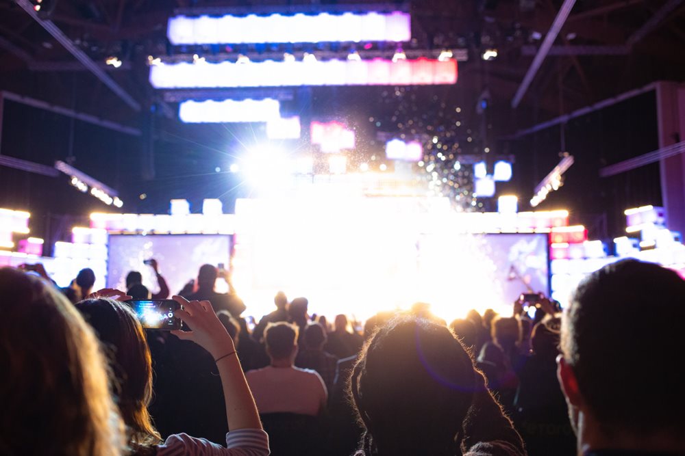 Audience at a presentation, recording with smartphones.