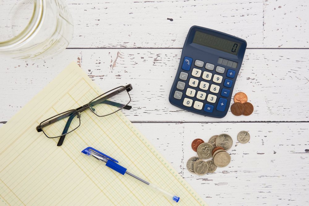 Calculator, coins, glasses, pen.