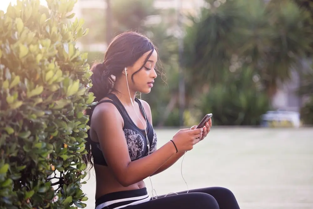 Young woman listening to music on her smartphone.