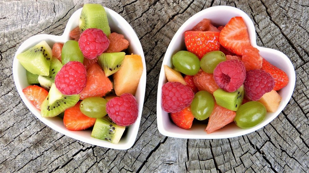 Heart shaped bowls, filled with fruit.