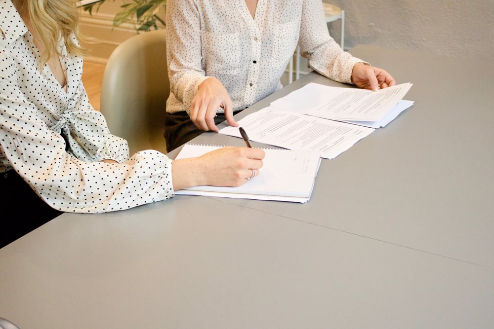 Two women, working with work related papers.