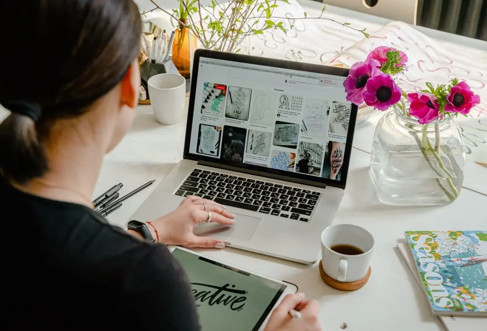 Woman scrolling through photos on laptop.