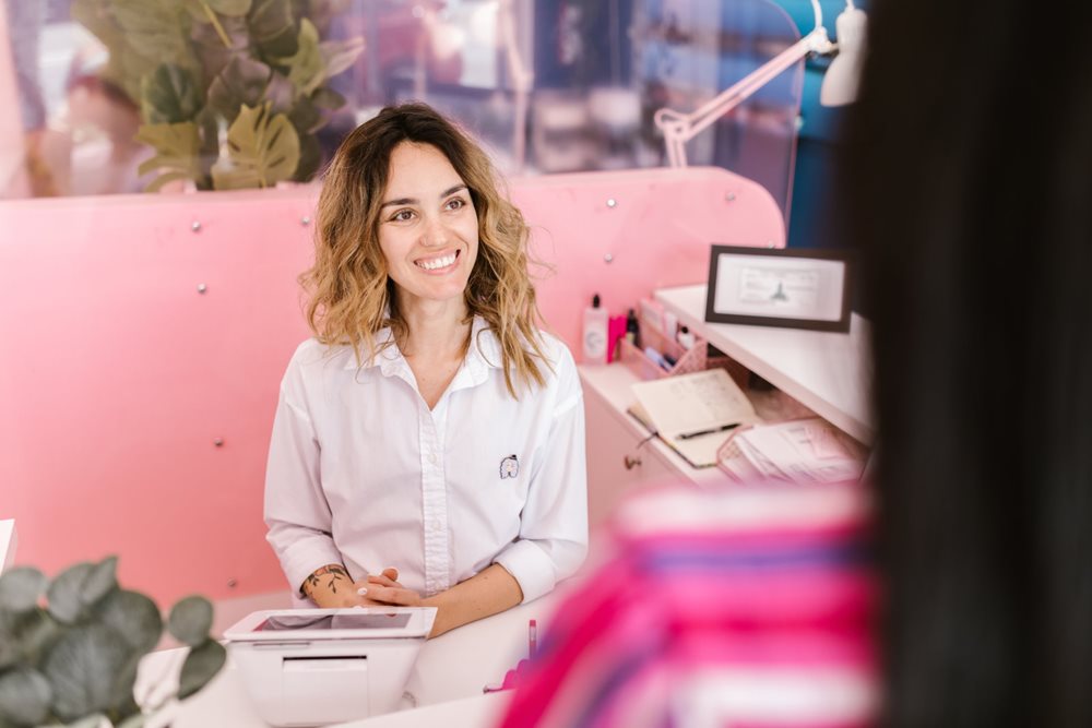 Friendly woman behind desk, servicing customer.