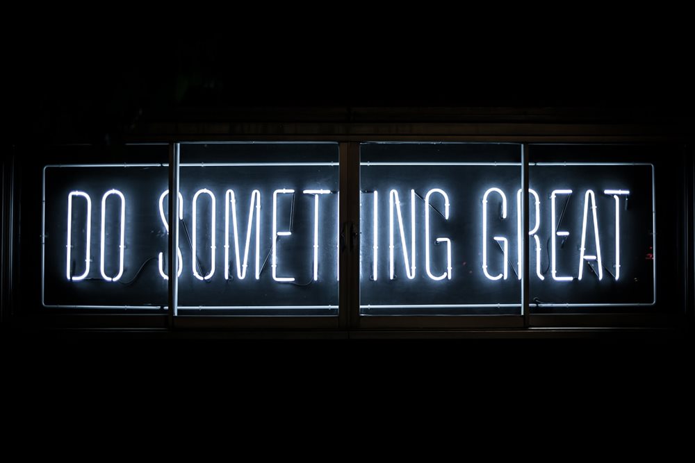 Neon sign that says "do something great".