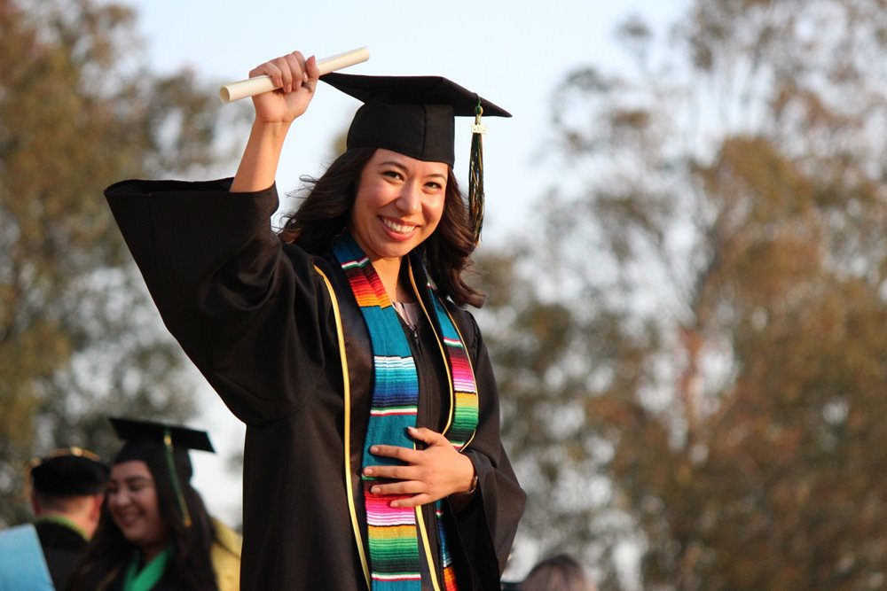 Graduated woman, holding diploma.