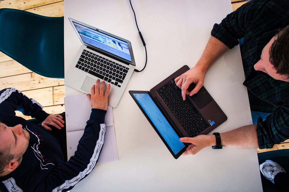 Two men working on their laptops.