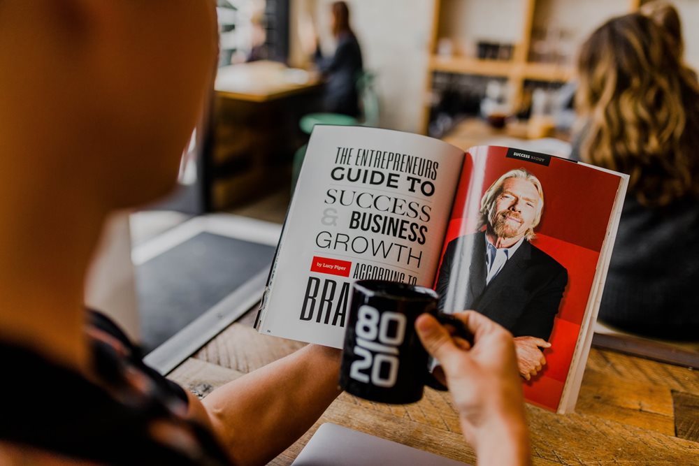 Person reading a book on business success.