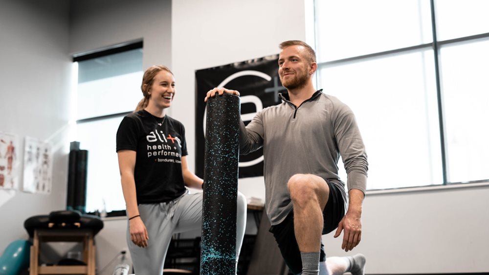 Man and woman, doing exercises with a foam roller.