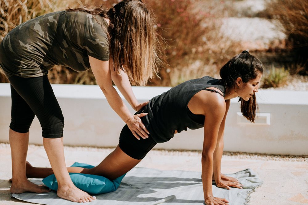 Personal trainer helping client do exercises.