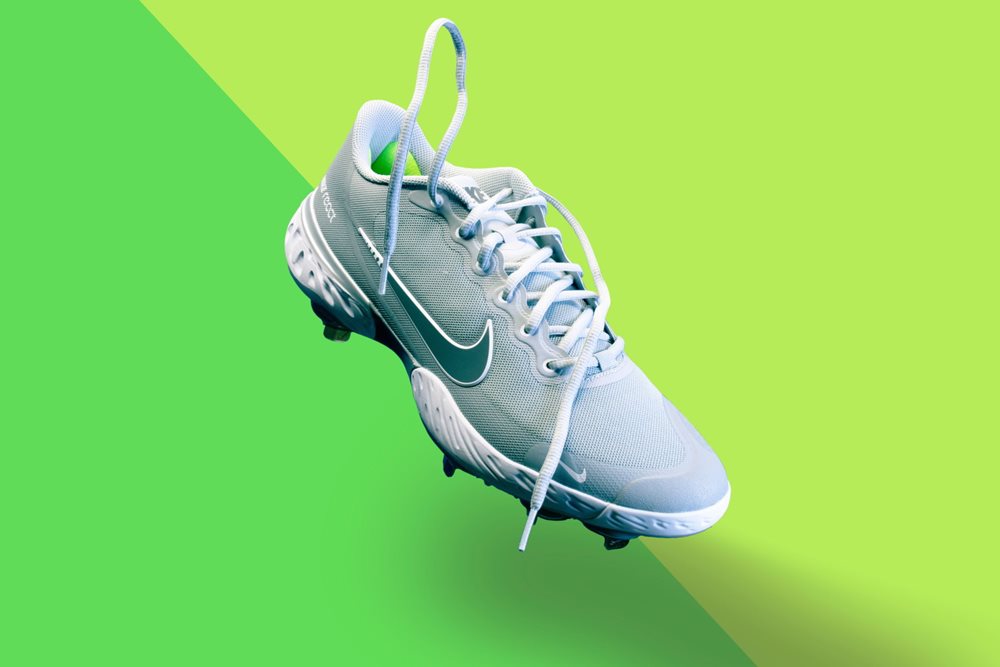 Light blue Nike sneaker on light green background.