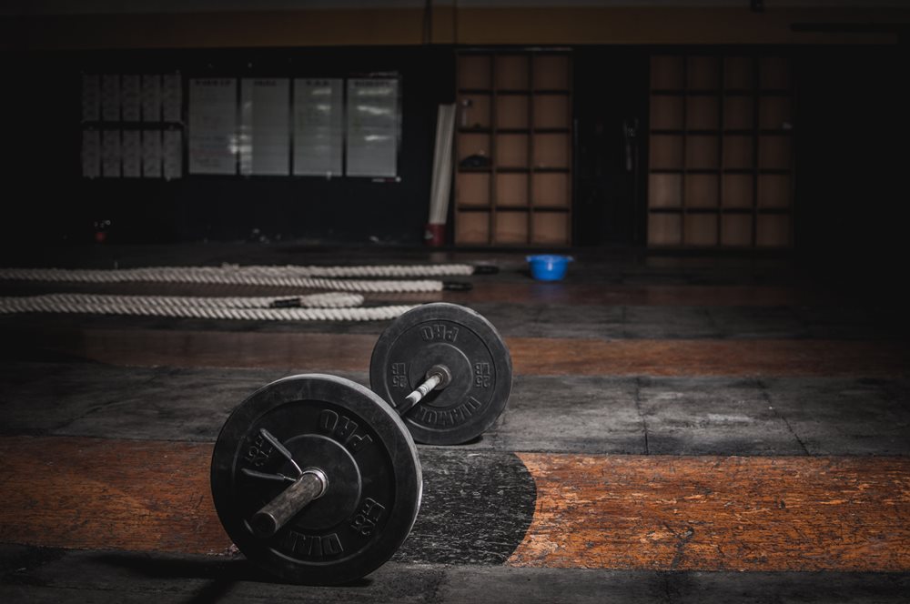 Barbell lying on floor in gym.