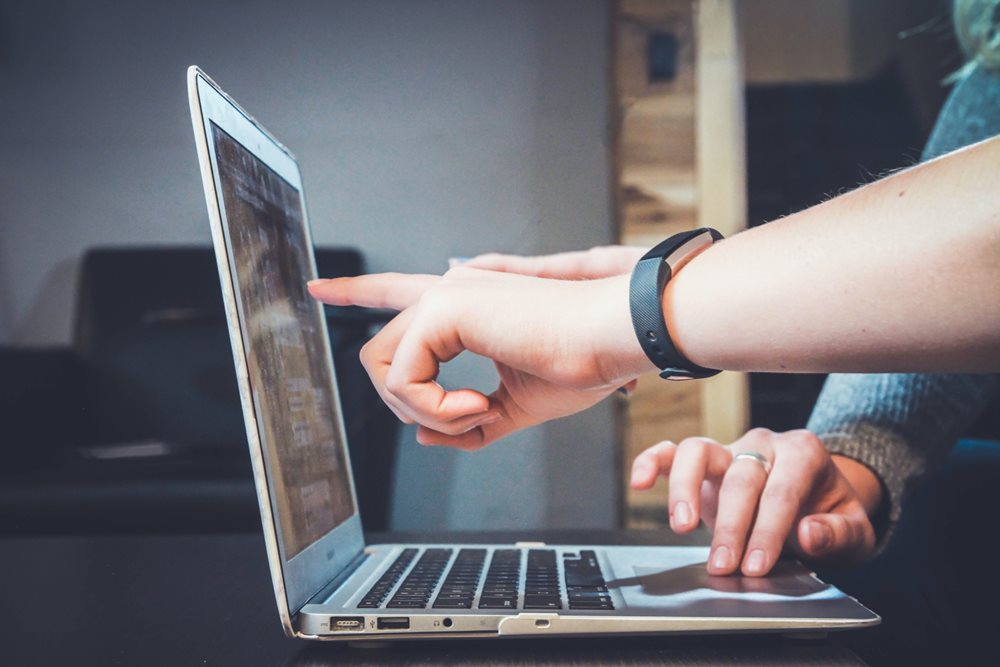 Woman pointing finger at laptop.