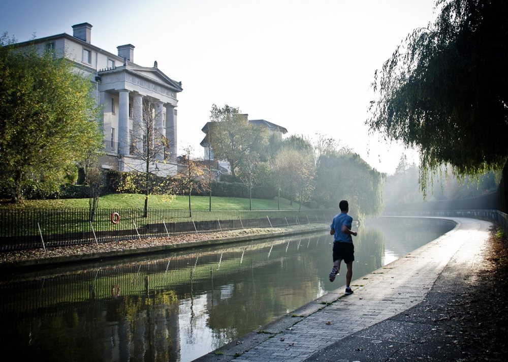 Man jogging along a ditch.