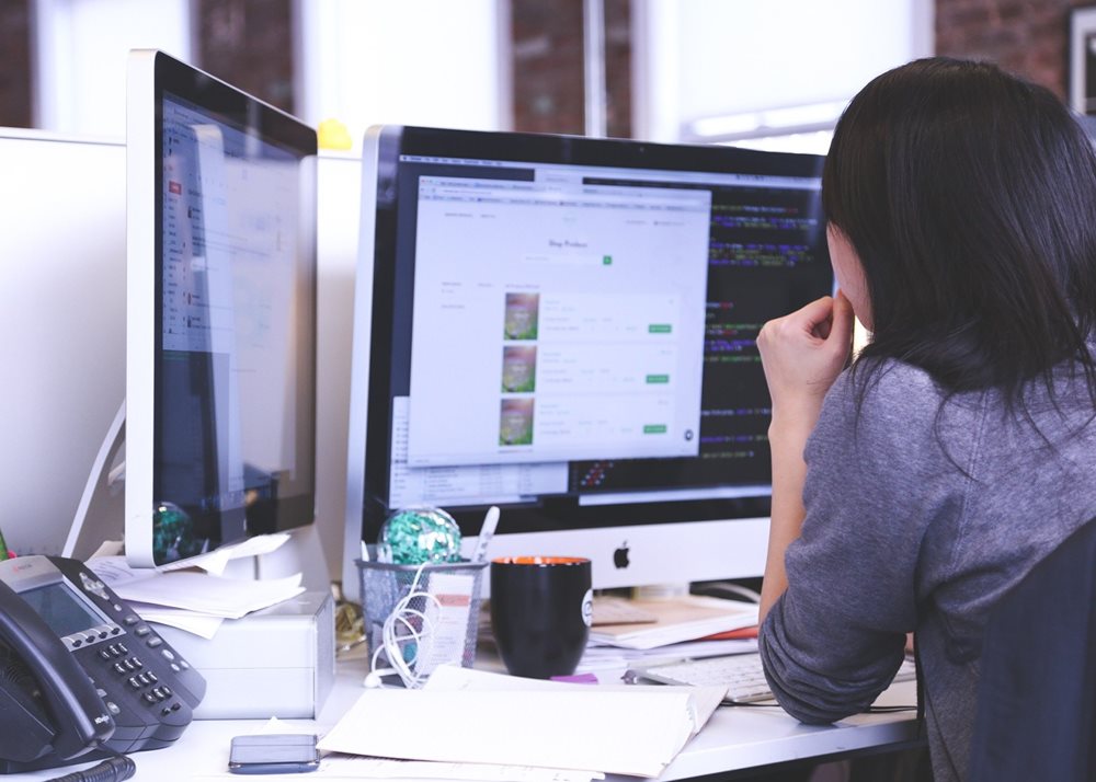 Woman working at computer at desk.