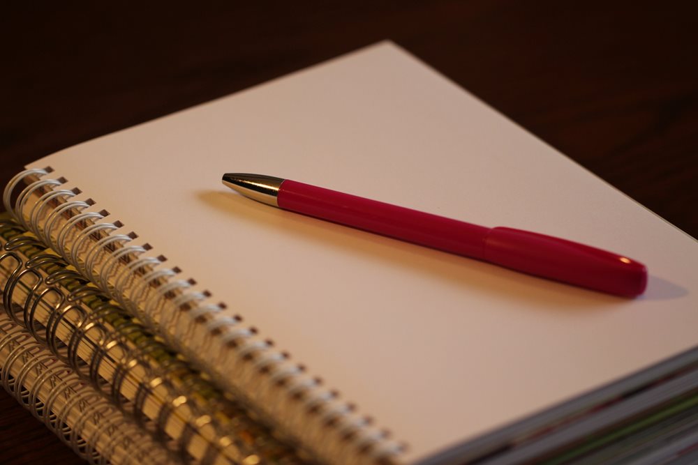 Pen lying on stack of noteblocs.