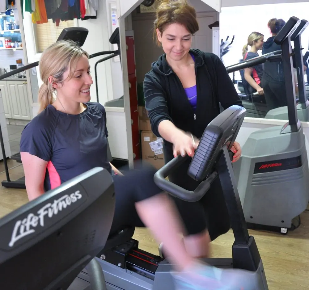 Personal trainer helping girl do cardio.