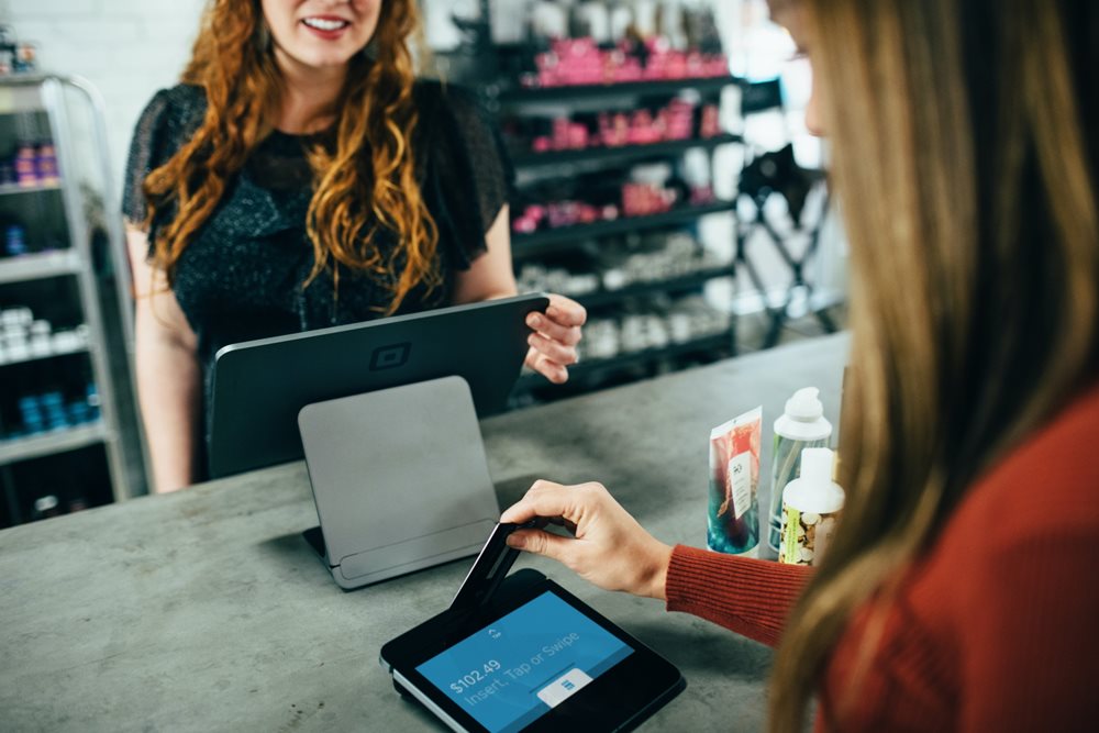 Woman paying at reception desk.